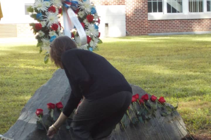 Darien&#x27;s Daughters of the American Revolution Regent Katherine Love places a rose on a monument on Sept. 11.