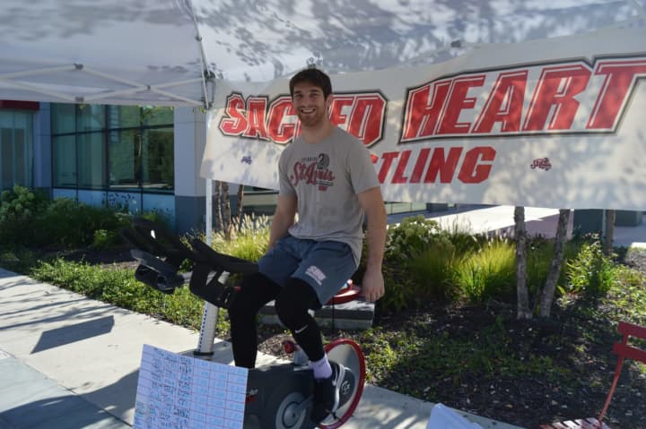 Sacred Heart University wrestling team captain Matt Fisher takes a turn on the stationary bike to raise funds for the Division 1 Pioneers.