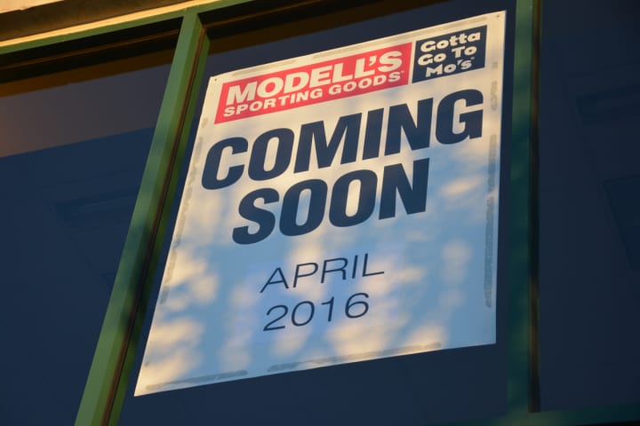 A sign posted on behalf of Modell&#x27;s Sporting Goods at its future Mount Kisco location announces that it will open this coming April.
