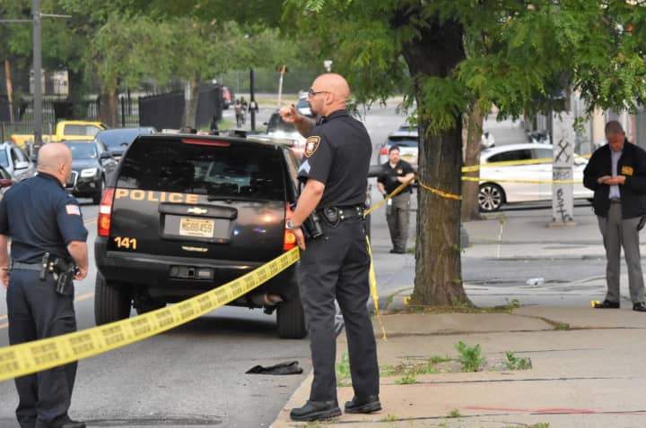 Uniformed Paterson police officers and investigators work the scene following the shooting on West Broadway near Oxford Street around 6 p.m. Monday, May 22.