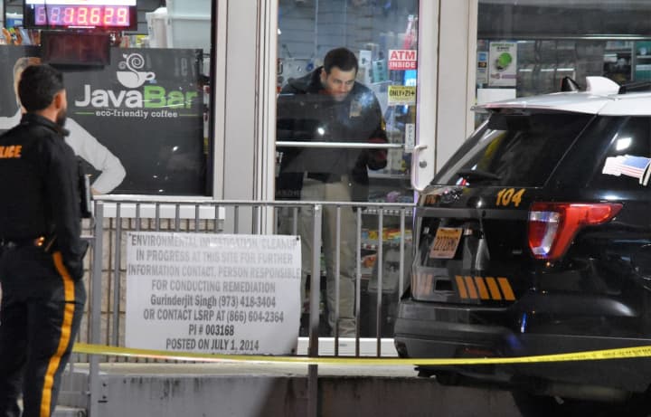 A member of the Bergen County Sheriff&#x27;s Bureau of Criminal Identification collects evidence at the Sunoco station on Polifly Road in Hackensack following the Sunday, March 19 robbery.