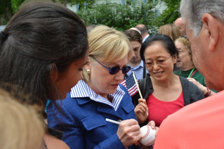 Hillary Clinton autographs a baseball while meeting community members prior to the start of New Castle&#x27;s 2016 Memorial Day parade.