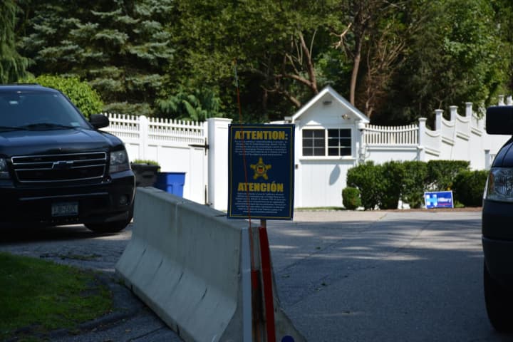 The entrance to the home of Hillary and Bill Clinton can be seen in the background at the end of Old House Lane in Chappaqua. The Secret Service has blocked traffic from driving to the end of the road with concrete barriers.