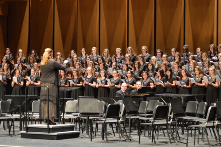 A student choral group performs at the Greenwich High School Performing Arts Center on its opening night. The school&#x27;s orchestra ensemble recorded a Mozart piece in the same space, which serves as music for callers on hold to town hall.