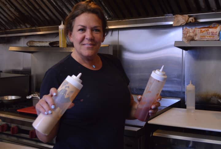 Holy Cow Sliders owner and chef Marlene Arute shows off some of her signature sauces.