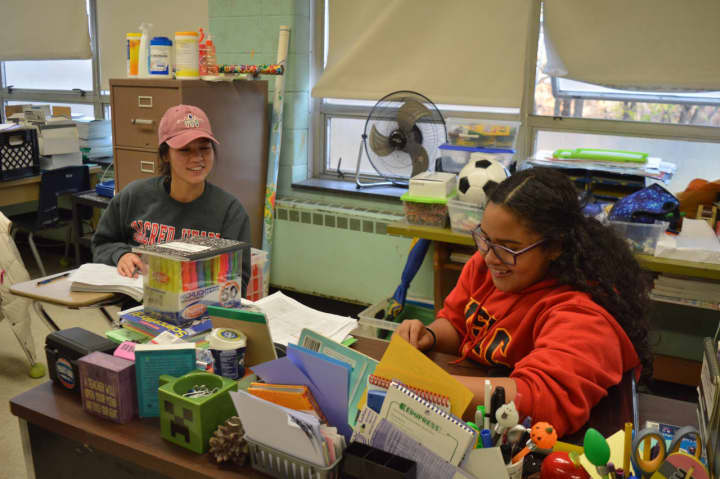 SHU sophomore Linh Nguyen and eighth-grader Natalie Lopez share a laugh through the Jones-Zimmermann Academic Mentoring Program at Winthrop School in Bridgeport.