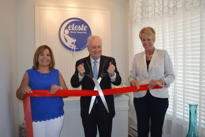 Fairfield First Selectman Michael Tetreau cuts the ribbon at Celeste Body Sugaring, while owner Alda Membrino and State Rep. Laura Devlin look on during the grand-opening ceremony.