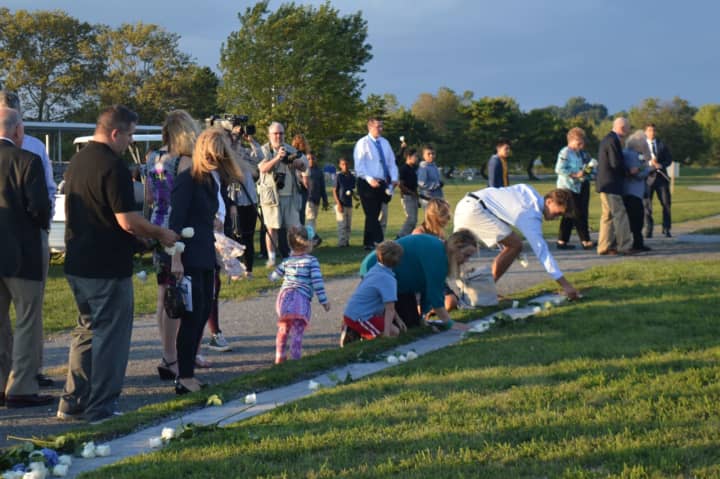 Friends and family leave white roses at the September 11th memorial at Sherwood Island State Park.