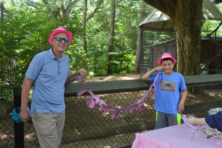 Craig Elkind and his son Wesley hold up the &#x27;It&#x27;s a Girl&#x27; sign outside the Canada lynx exhibit at Beardsley Zoo. Wesley and his brother Spencer named the two new lynx kittens Penny and Ruby.