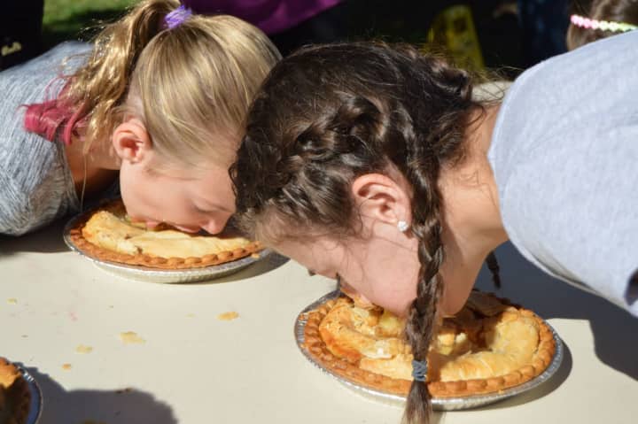 Kids dig in for the pie-eating contest last Saturday at the 7th annual Country Fair at the Easton Public Library.