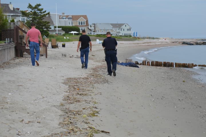 Fairfield police wait with the body of a man that washed up on shore Thursday afternoon.