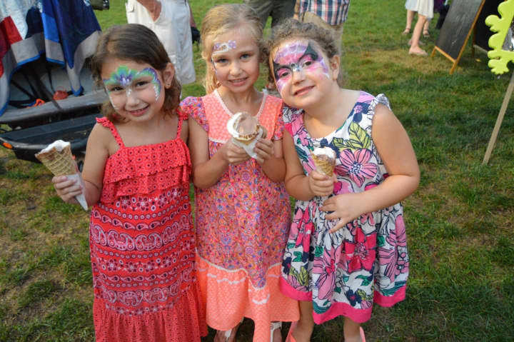 Young ladies enjoy their icecream after getting their faces painted at Shelton Sounds.