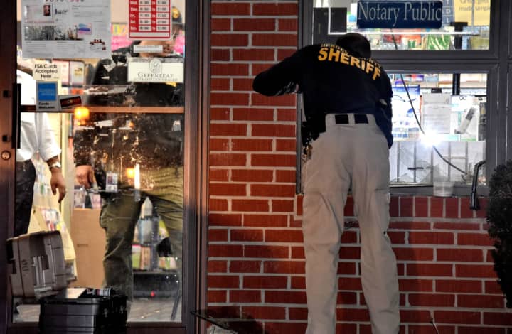 Bergen County Sheriff&#x27;s BCI detective gathers evidence at Hudson Drug at 48 Union Avenue in Cresskill.