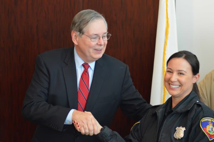 Mayor David Martin shakes hands with Officer Nicole Petrenko, who found the suspects&#x27; getaway car while on patrol. 