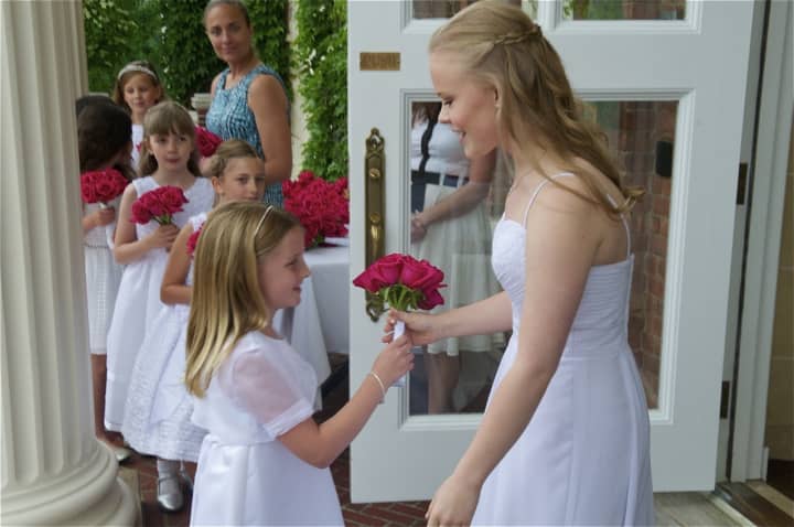 Second-graders hand the graduates roses as they make their final walk to graduation at Sacred Heart Greenwich on Friday.