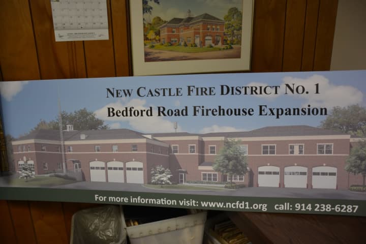 A photo of a rendering that shows the proposed Bedford Road firehouse expansion in Chappaqua. The rendering is included with a voting information sign.