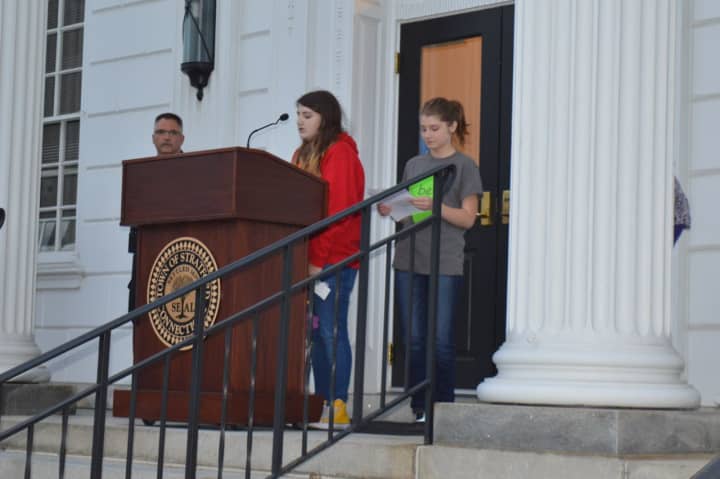 Stratford High School students Melissa Wilson, left, and Kathryn Cullen help read the names of those lost to domestic violence in Connecticut in 2015 at a Stratford vigil.