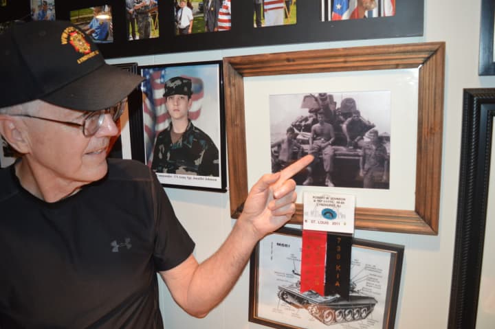 Thomas Graffam points to a picture of Robert &quot;Wayne&quot; Johnson on the wall of the VFW hall