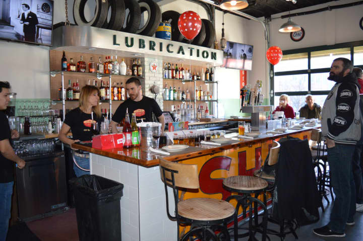 The bar at PizzaCo features reclaimed wood and a original Shell station sign.