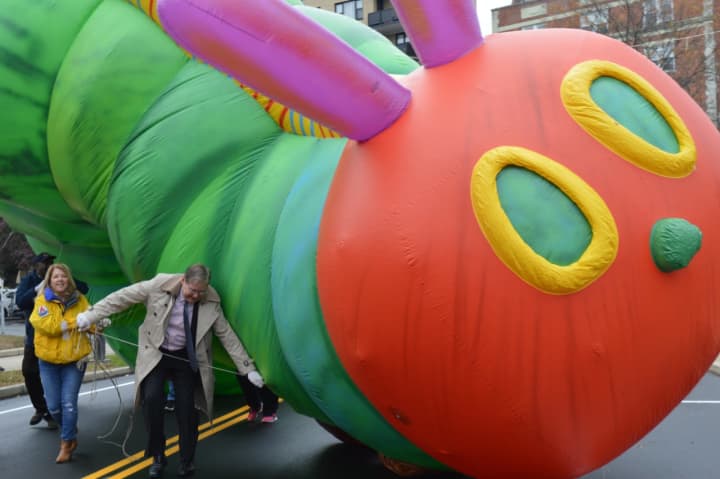 Stamford Mayor David Martin works to bring The Very Hungry Caterpillar until some wires during the preview to the 24th annual Stamford Downtown Parade Spectacular.