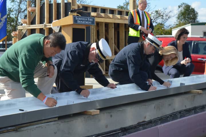 Fairfield dignitaries sign a steel beam before it&#x27;s placed atop the new Fairfield Regional Fire Training School.