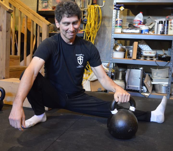 Steve Freides stretching with a kettlebell.