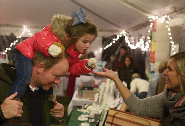 A little girl and her dad shop at the Rowayton Historical Society&#x27;s Holiday Bazaar, part of the Light Up Rowayton event on Sunday.