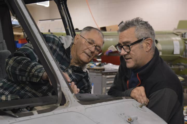 Charlie Vesterman and Tim Benson work on an aircraft at the Connecticut Air and Space Center.