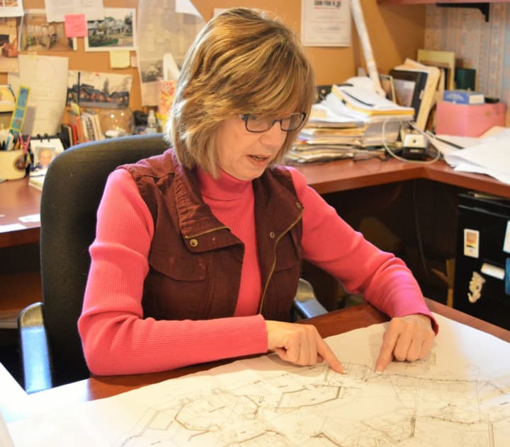 Architect Linda Del Nobile Menze reviewing a blueprint in her Park Ridge office.