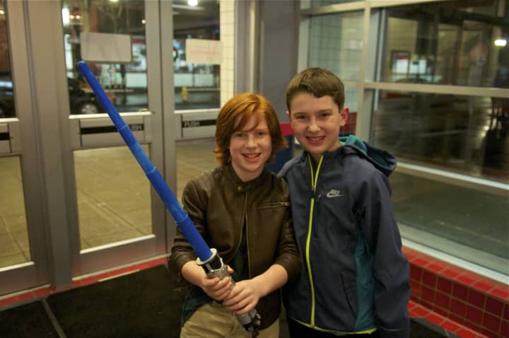 A boy holds a light saber as he and a buddy head in to see &quot;Star Wars: The Force Awakens&quot; on Thursday evening in Stamford.