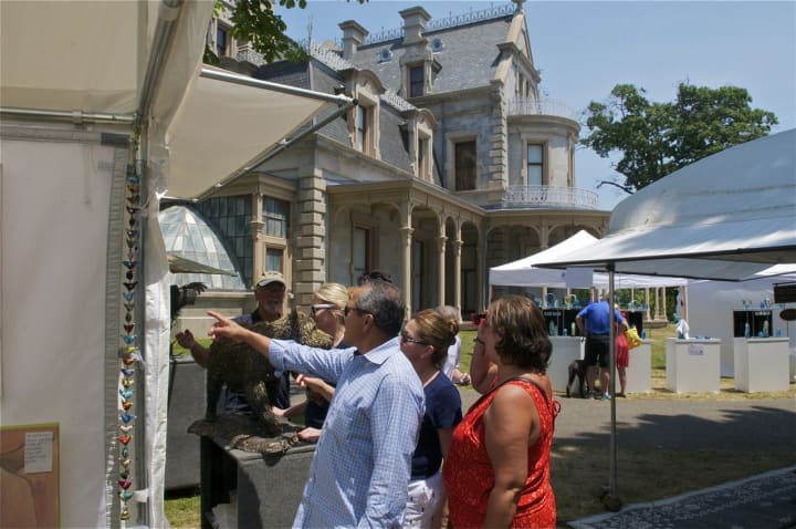 Visitors view artwork at the Norwalk Art Festival on Sunday in the shadow of the Lockwood-Mathews Mansion.