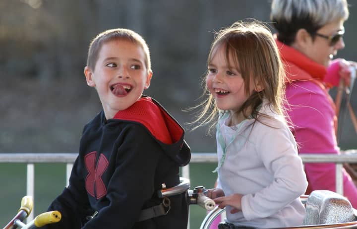 Two happy youngsters enjoy one of the many kids rides at Trumbull&#x27;s Rotary Carnival.