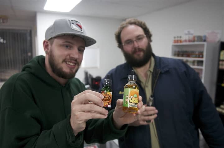 Dave&#x27;s E Cig Shop&#x27;s Scott Martin (R) shows a customer some of the store&#x27;s popular flavors.