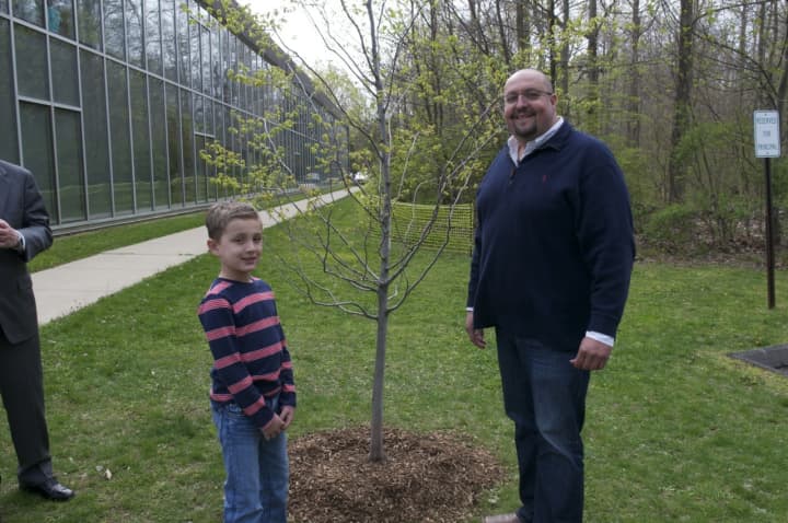 Burr Elementary second-grader Evander Prapopulos and Tree Warden Jeff Minder with the Hornbeam Ironwood tree they planted.