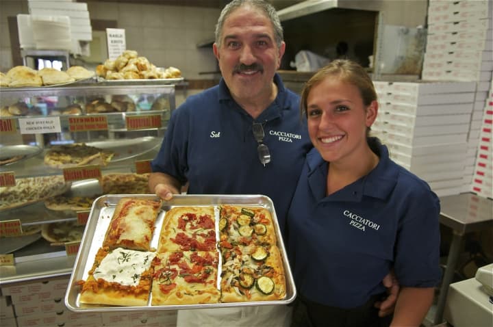Cacciatori Pizza owner Sal Triarsi and Jennie Pagliuca show off some of their popular pizzas.
