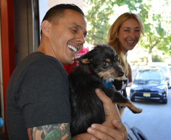 Guerrilla Fitness owner Joe Ghaznavi and Robyn Hendrix play with an adoptable dog.