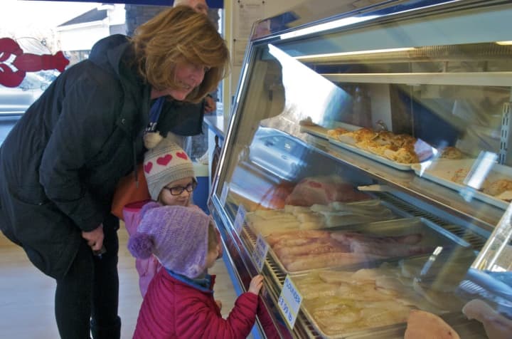 Area residents partaking in the Feast of Seven Fishes make their purchases Friday at Four Maples Fish in Poughkeepsie. Saturday will be the busiest day of the year for area fish markets.