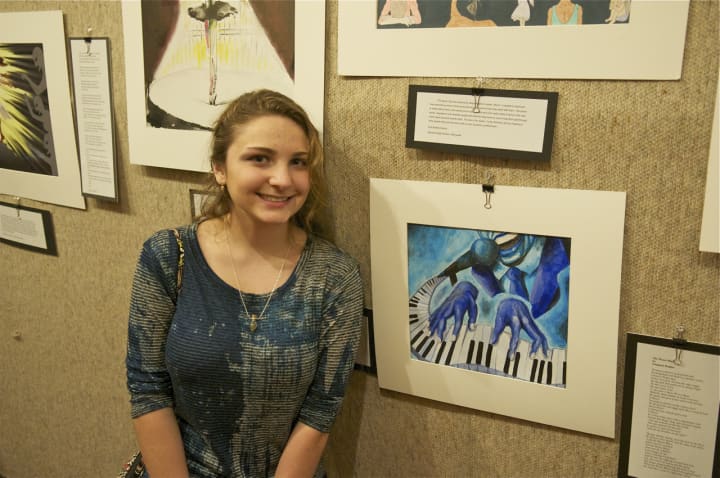 Madison Delelle of Stamford High School stands next to her artwork at Sunday&#x27;s reception for students at the Sackler Art Gallery at Stamford&#x27;s Palace Theatre.