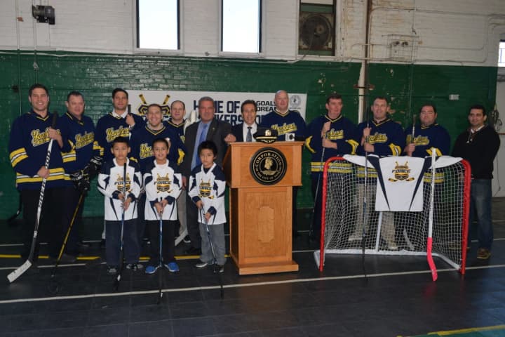 Yonkers Mayor Mike Spano with the gear donated by the NHL Players&#x27; Association to help outfit the Yonkers Force hockey team.