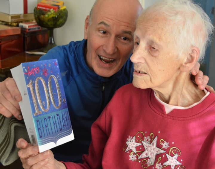 Steve Boyle with his mother, Helen Boyle, as she reads one of her 100th birthday cards.