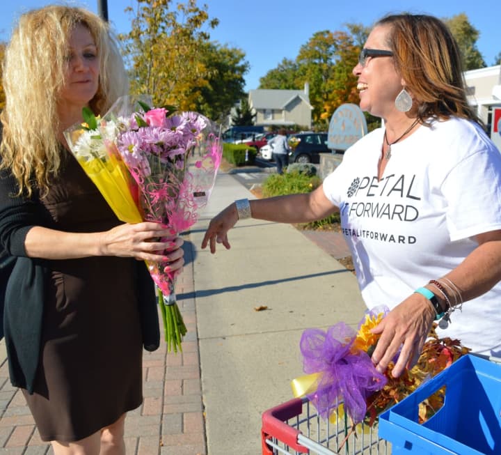 Tyrrells Floral Designer Lisa Mayfield, right, giving out free bouquets in Westwood.