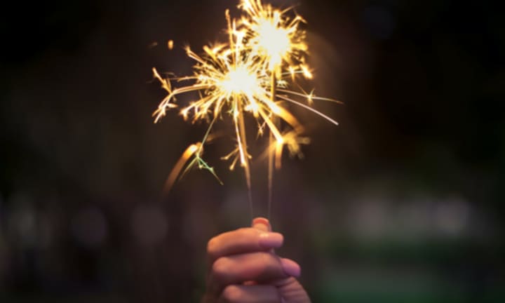 Person holding a lighted sparkler