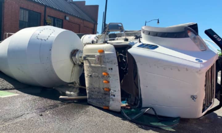 The overturned concrete truck sent fuel and concrete in the roadway