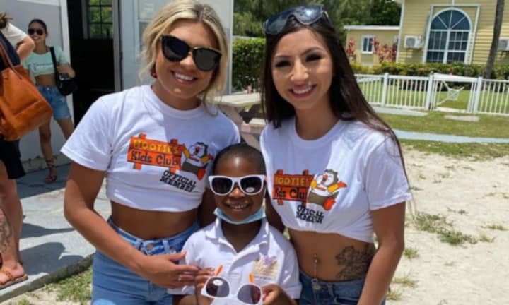 Hooters Girls pose with a student from Gateway Christian Academy in Bimini