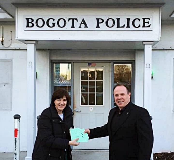 Daniele Fede donates Fix It Up Raffle tickets to the Bogota Police Department&#x27;s Chief Daniel Maye.