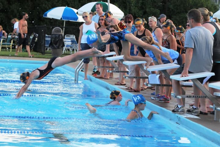 Young swimmers start the race in the 15-yard freestyle.