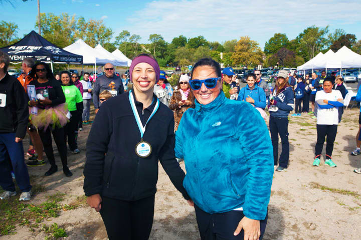 Emily Walgenbach of Stamford, CancerCare’s Walk/Run for Hope Women’s 5 K winner (left), with Corey Cenatiempo, Regional Special Events Manager for CancerCare, right, at Jennings Beach in Fairfield on Oct. 4.