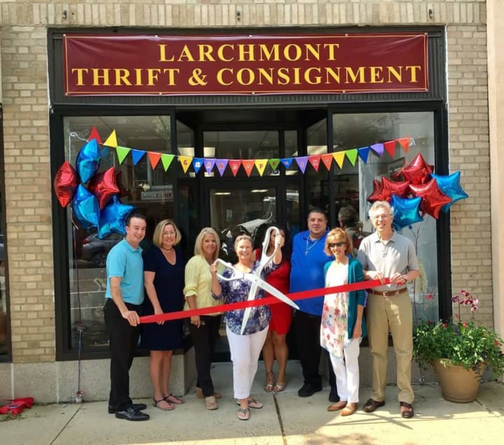 Larchmont Mayor Lorraine Walsh (with scissors), Village trustees and Chamber of Commerce board members at the ribbon cutting for Larchmont Thrift &amp; Consignment.