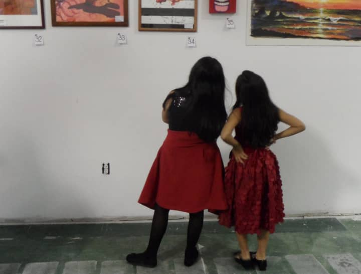 Two girls contemplate art work on display.