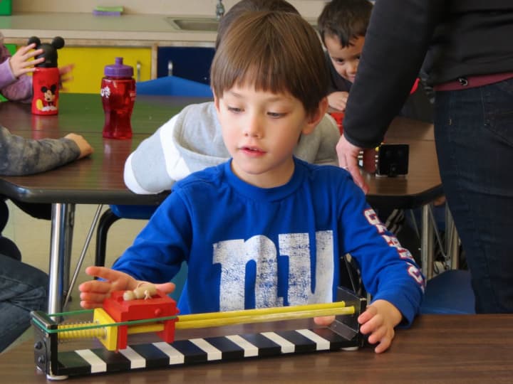 Wesley Cotrone, a kindergartner at Increase Miller Elementary School, uses a device to practice the forces of pulling and pushing.